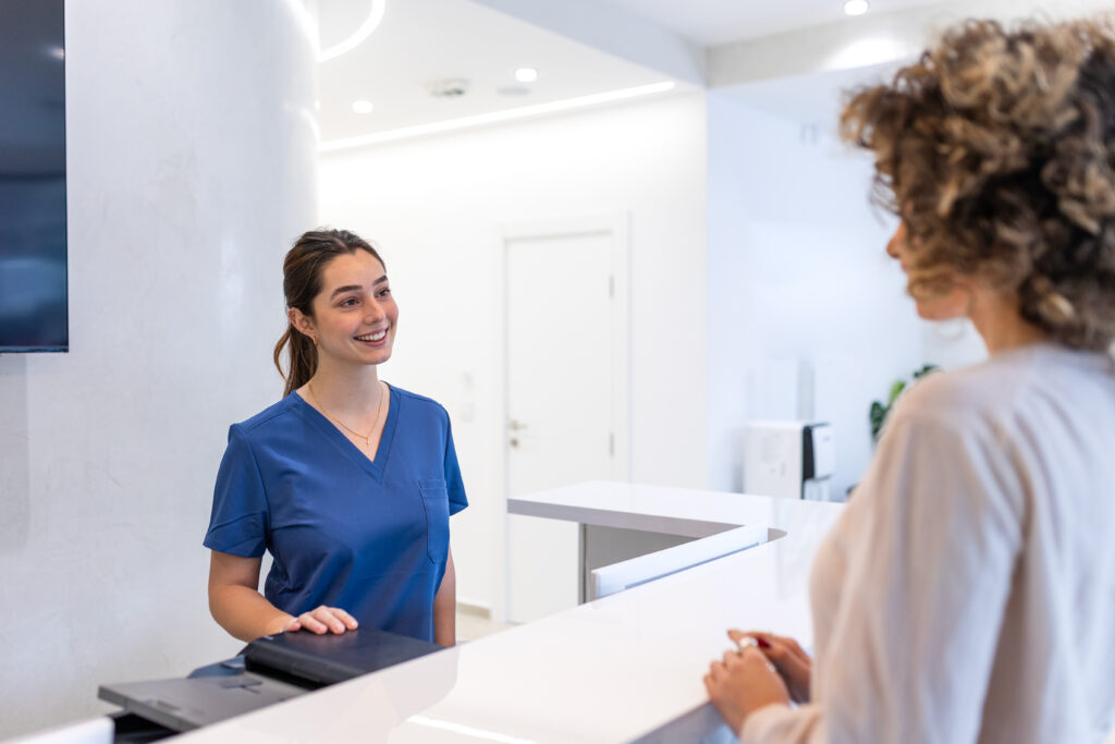 Welcoming medical receptionist assisting the patient